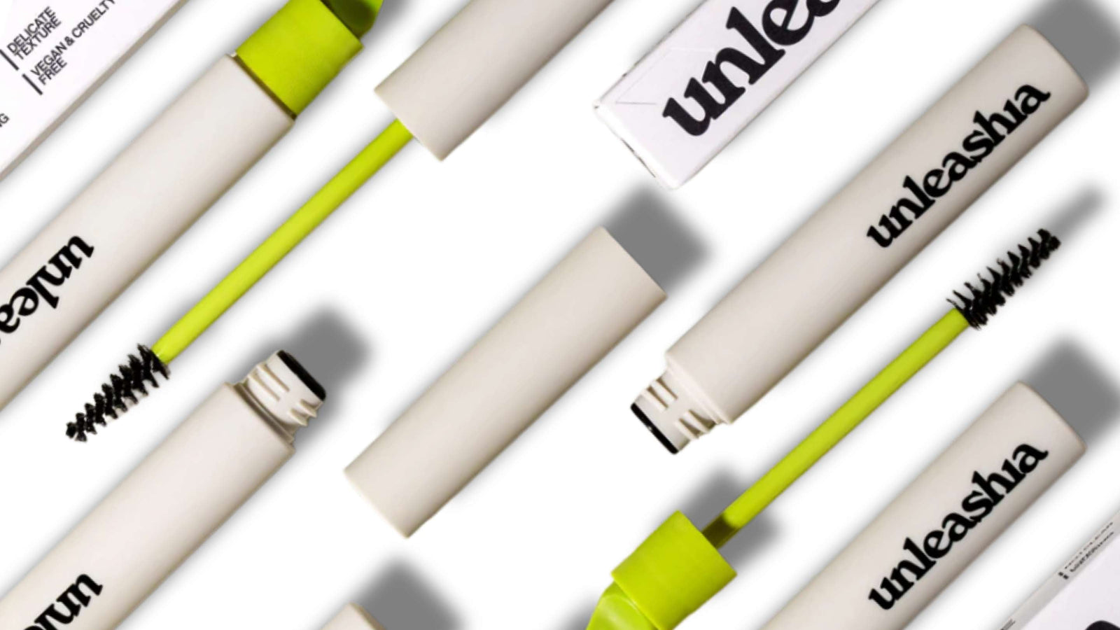 Bilden visar flera ögonbrynsverktyg från märket Unleasha, inklusive penslar och tuber för ögonbrynspomade. Produkterna är stilfullt presenterade mot en neutral bakgrund, vilket framhäver deras sofistikerade och moderna design.