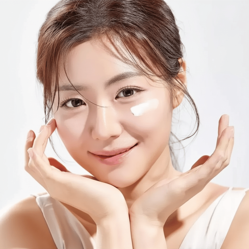 Kvinne påfører Round Lab 1025 Dokdo Eye Cream under øynene for fuktighet, glød og en jevnere hudtone