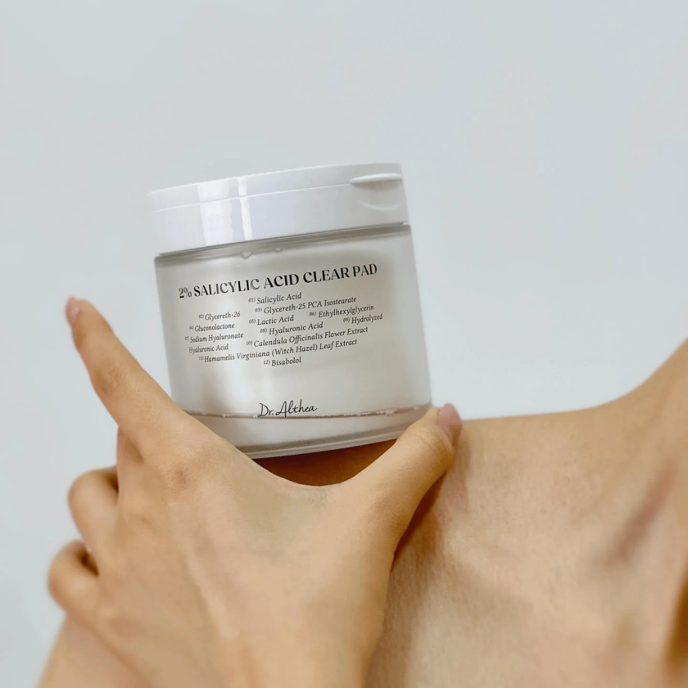 Dr. Althea 2% Salicylic Acid Clear Pad holdes i hånden. Toner pads med 2% salisylsyre som eksfolierer skånsomt, beroliger huden og forbedrer hudstrukturen.