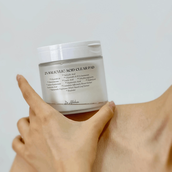 Dr. Althea 2% Salicylic Acid Clear Pad holdes i hånden. Toner pads med 2% salisylsyre som eksfolierer skånsomt, beroliger huden og forbedrer hudstrukturen.