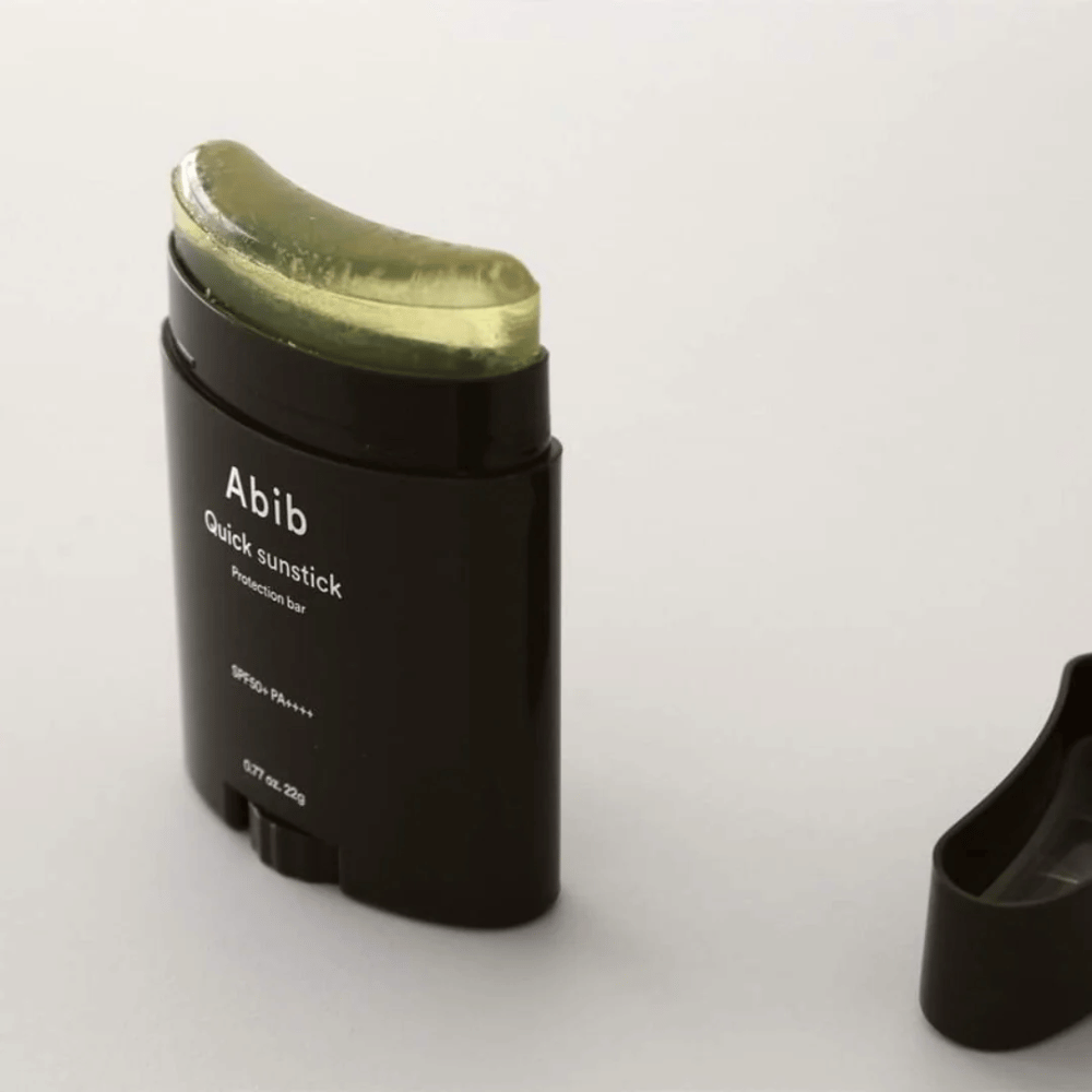Et svart rør med grønt lokk, inneholdende Quick Sunstick Protection Bar SPF50+ PA++++ 22g fra Abib for solbeskyttelse.