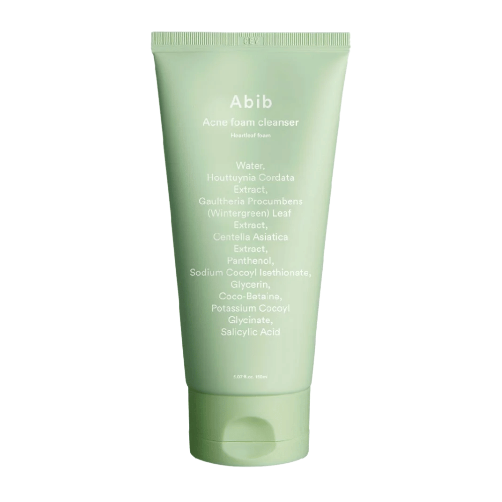Grønn tube med Abib Acne Foam Cleanser Heartleaf Foam, viser ingredienser som Houttuynia Cordata, Centella Asiatica og salisylsyre trykt på forsiden. Produktet står oppreist mot hvit bakgrunn.