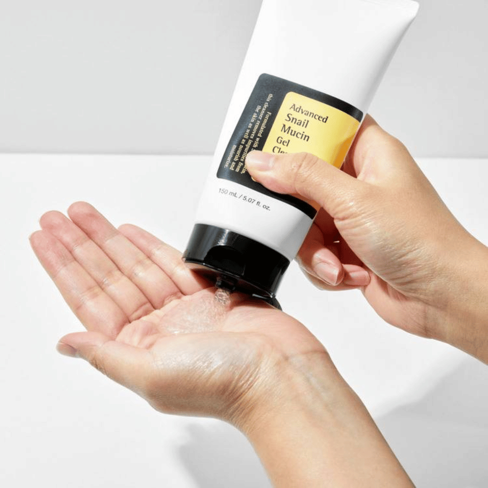 Hånd påfører COSRX Advanced Snail Mucin Gel Cleanser – skånsom gelrens med snegleslim som renser dypt og bevarer hudens fuktbalanse.