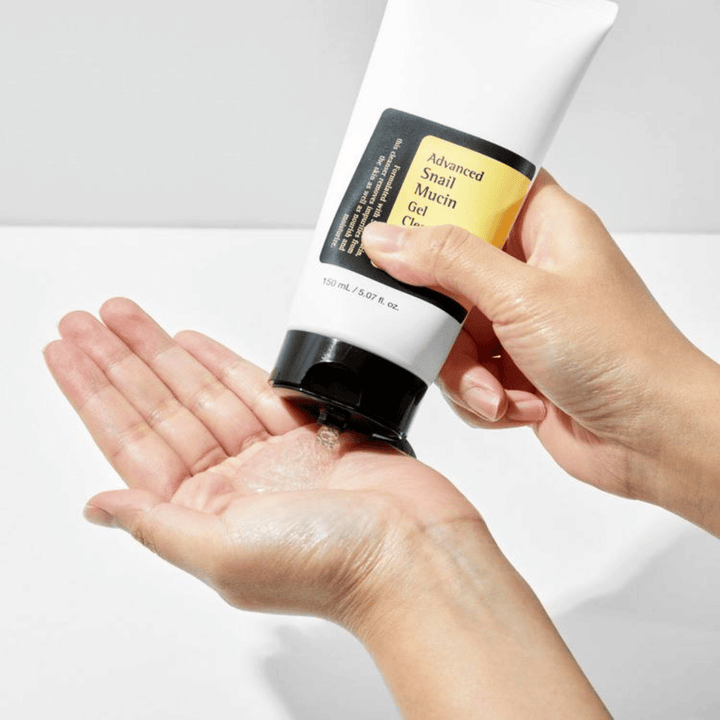 Hånd påfører COSRX Advanced Snail Mucin Gel Cleanser – skånsom gelrens med snegleslim som renser dypt og bevarer hudens fuktbalanse.