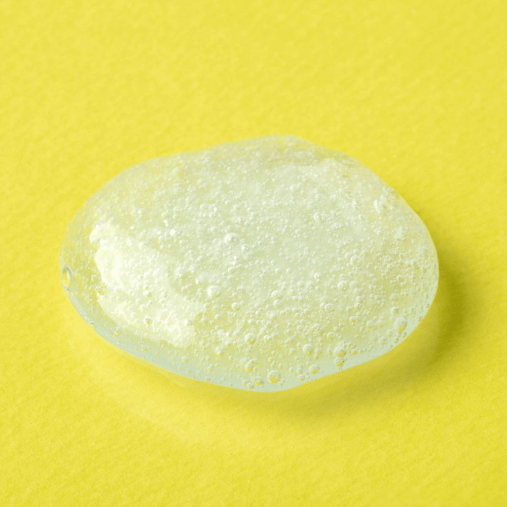 Transparent geltekstur fra COSRX Advanced Snail Mucin Gel Cleanser på gul bakgrunn – fuktighetsgivende ansiktsrens med sneglesekret for myk og balansert hud.