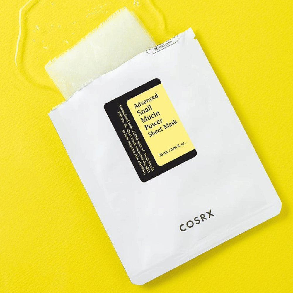 COSRX Advanced Snail Mucin Power Sheet Mask på gul bakgrunn, en fuktighetsgivende og reparerende ansiktsmaske med snegleekstrakt for økt elastisitet og glød.
