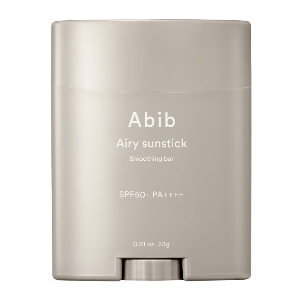 Bildet viser en beige solbeskyttelsesstift fra Abib med teksten "Airy Sunstick Smoothing Bar" og solbeskyttelsesfaktor SPF50+ PA++++, perfekt for daglig beskyttelse mot UV-stråler.