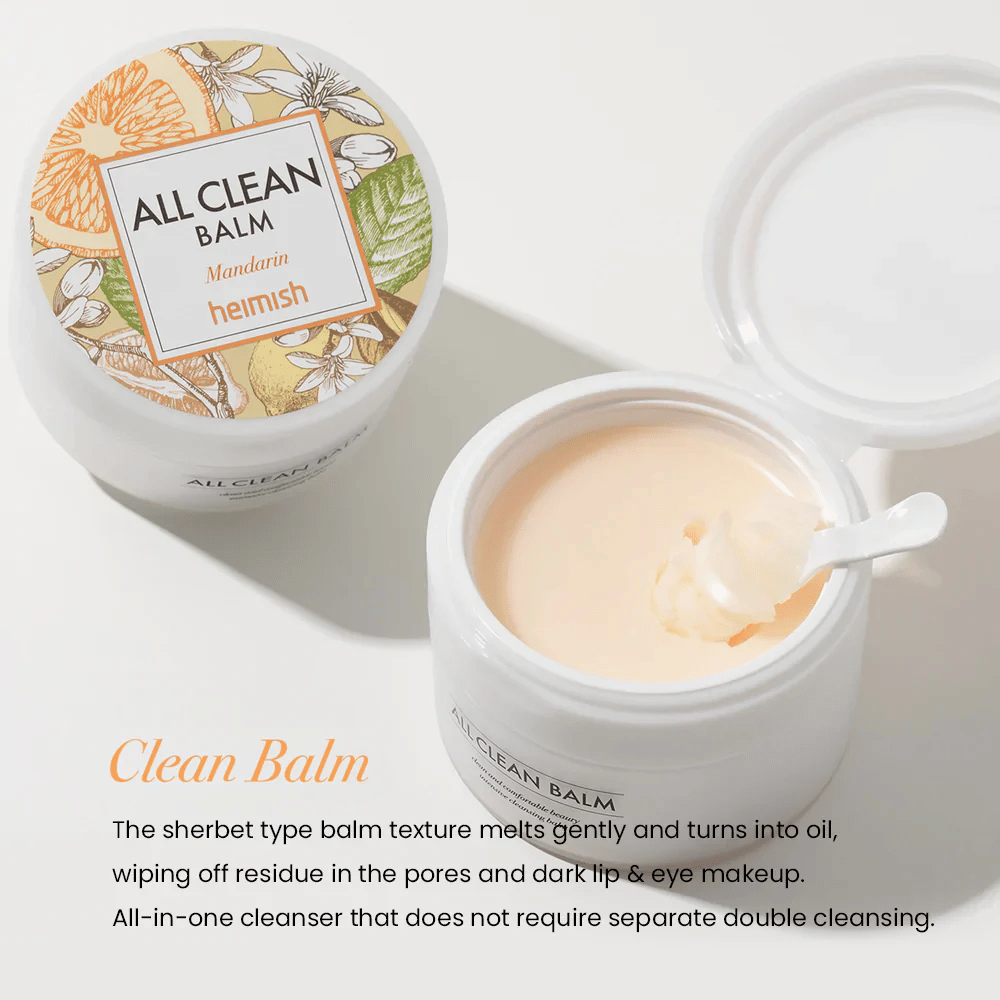 Åpen krukke av Heimish All Clean Balm Mandarin med en skje som rører rundt i den kremete rengjøringsbalmen, med en fargerik etikett og teksten 'Clean Balm' i forgrunnen.