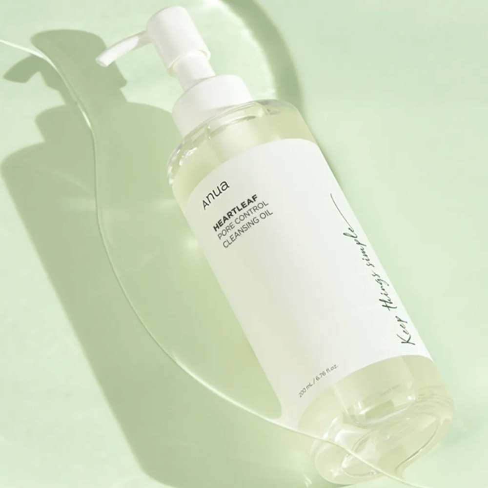 På bildet sees ANUA Heartleaf Pore Control Cleansing Oil, en renseolje med pumpedesign. Flasken er gjennomsiktig og innholdet ser ut til å ha en lett, oljete konsistens. Etiketten bærer merkevarens logo og produktnavn i enkel og stilren tekst, noe som bidrar til en følelse av minimalistisk skjønnhet og renhet. Det står "Keep things simple" som en del av designet, noe som antyder en filosofi om enkelhet i hudpleierutinen. Flasken inneholder 200 ml produkt.