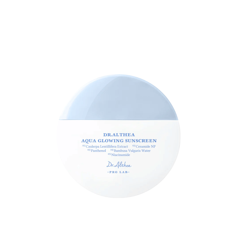 Produktbilde av Dr. Althea Aqua Glowing Sunscreen – en rund solkrem i hvit og lyseblå emballasje med tekst i blått som fremhever fuktighetsgivende ingredienser som niacinamid og ceramider.