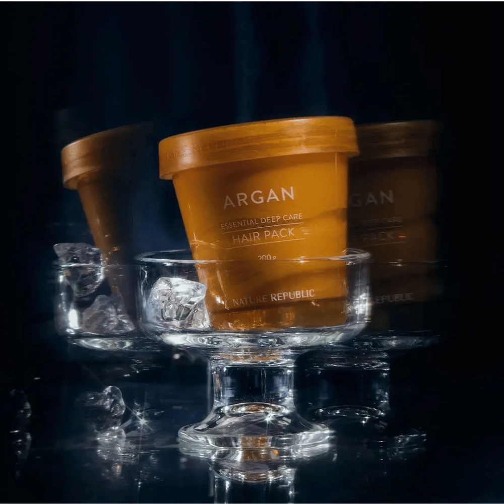 Nature Republic Argan Essential Moisture Repairing Hair Mask plassert på glassfat med isbiter – luksuriøs og pleiende hårmaske.