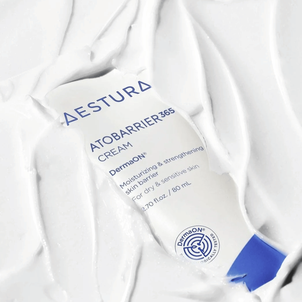 Aestura Atobarrier 365 Cream er perfekt for tørr og sensitiv hud. Med DermaON™ teknologi, fukter og styrker denne kremen hudbarrieren. Produktet vises her i en 80 ml tube, delvis dekket av sin egen kremete konsistens, som fremhever dens rike, fuktighetsgivende egenskaper.