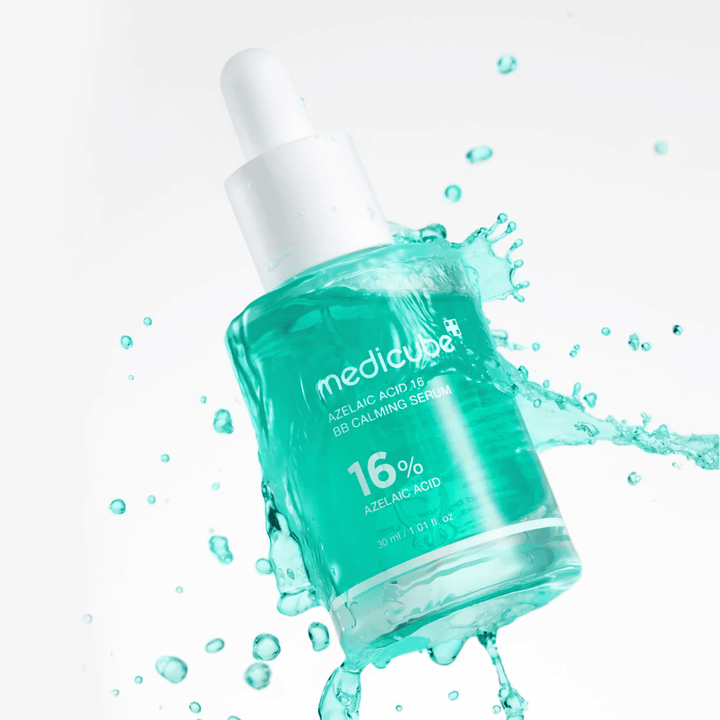 Dynamisk produktbilde av Medicube Azelaic Acid 16 BB Calming Serum omgitt av vannsprut som fremhever en frisk, lett og fuktighetsgivende følelse.