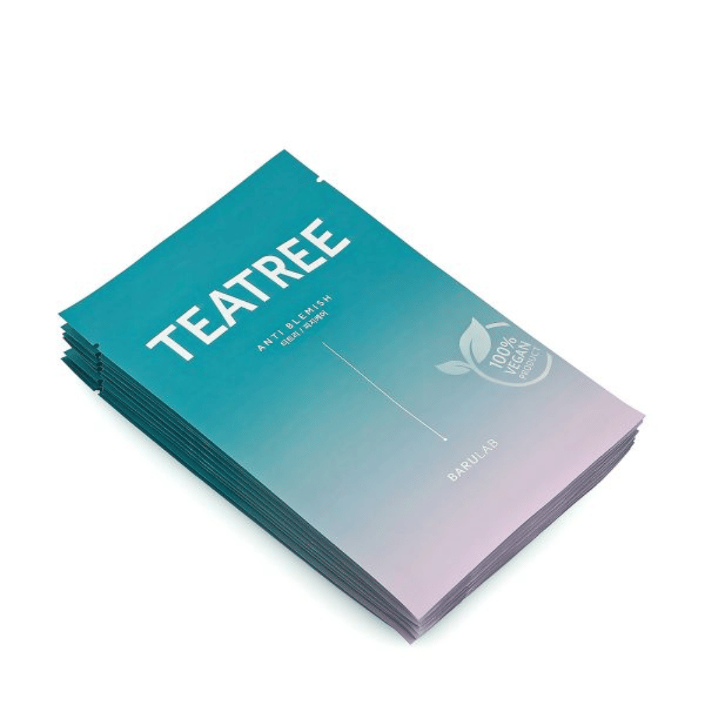 En haug av pakker med BARULAB "TEATREE Anti Blemish" masker, alle merket som "100% Vegan Product". Pakningene har en enhetlig turkis farge.