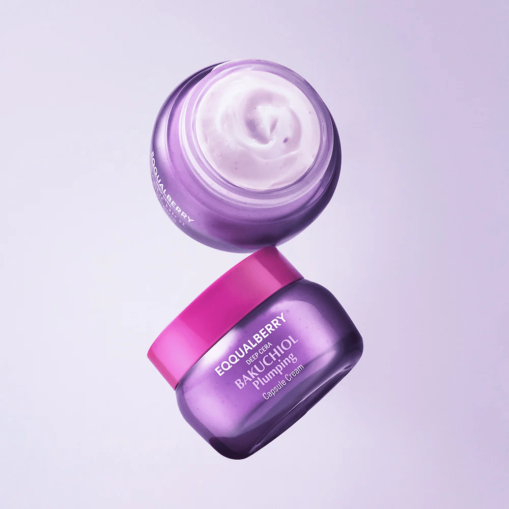 To åpne beholdere av EQQUALBERRY Bakuchiol Plumping Capsule Cream i lilla emballasje med rosa lokk. Kremens myke tekstur er tydelig synlig ovenfra.