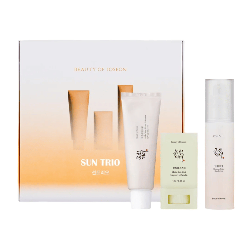 Beauty of Joseon - Sun Trio gaveeske med tre solbeskyttelsesprodukter: Relief Sun Rice + Probiotics, Matte Sun Stick Mugwort + Camellia og Ginseng Moist Sun Serum foran en gradientpakning i hvitt og oransje.