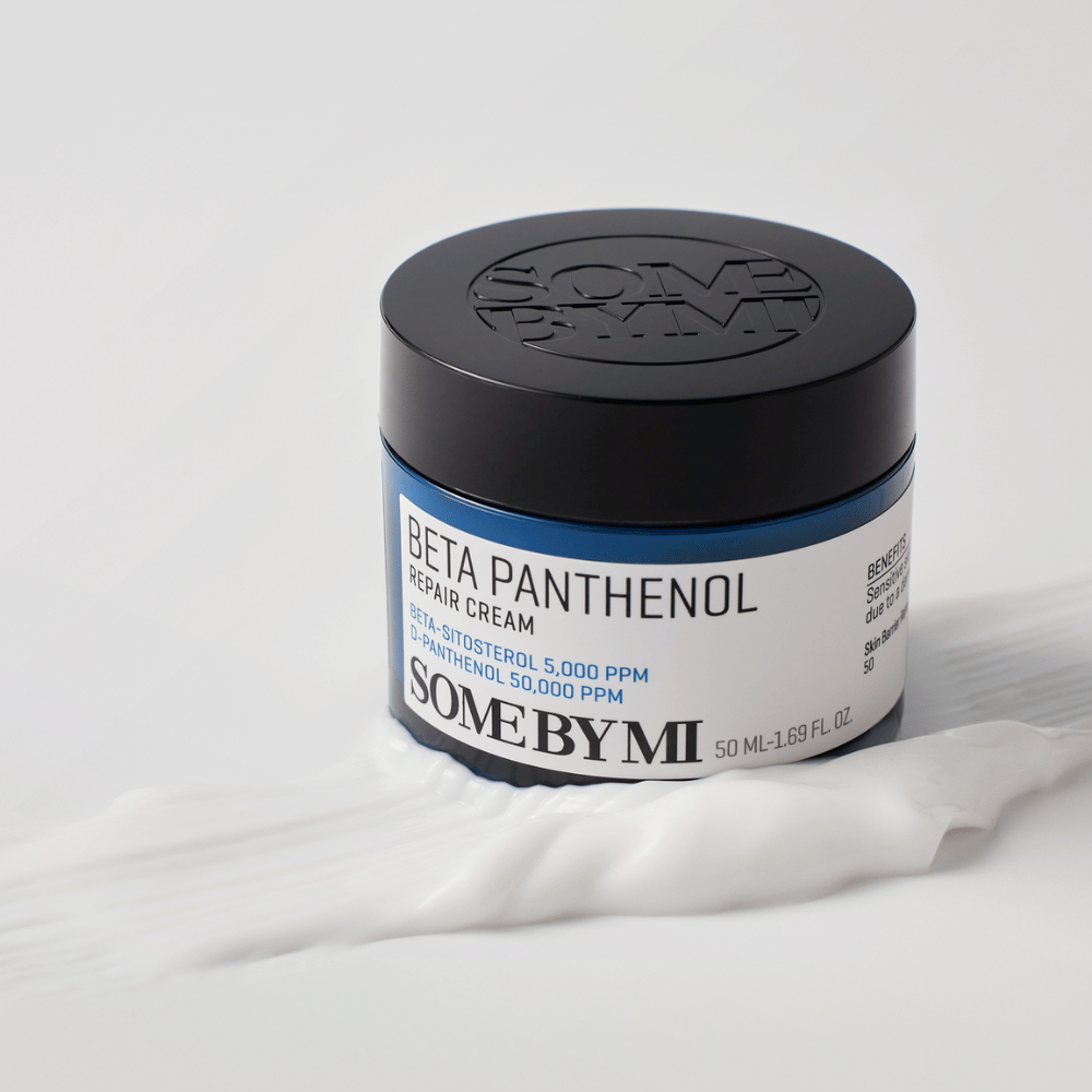 SOME BY MI Beta Panthenol Repair Cream i blå krukke plassert på kremtekstur – beroligende og fuktighetsgivende hudkrem.
