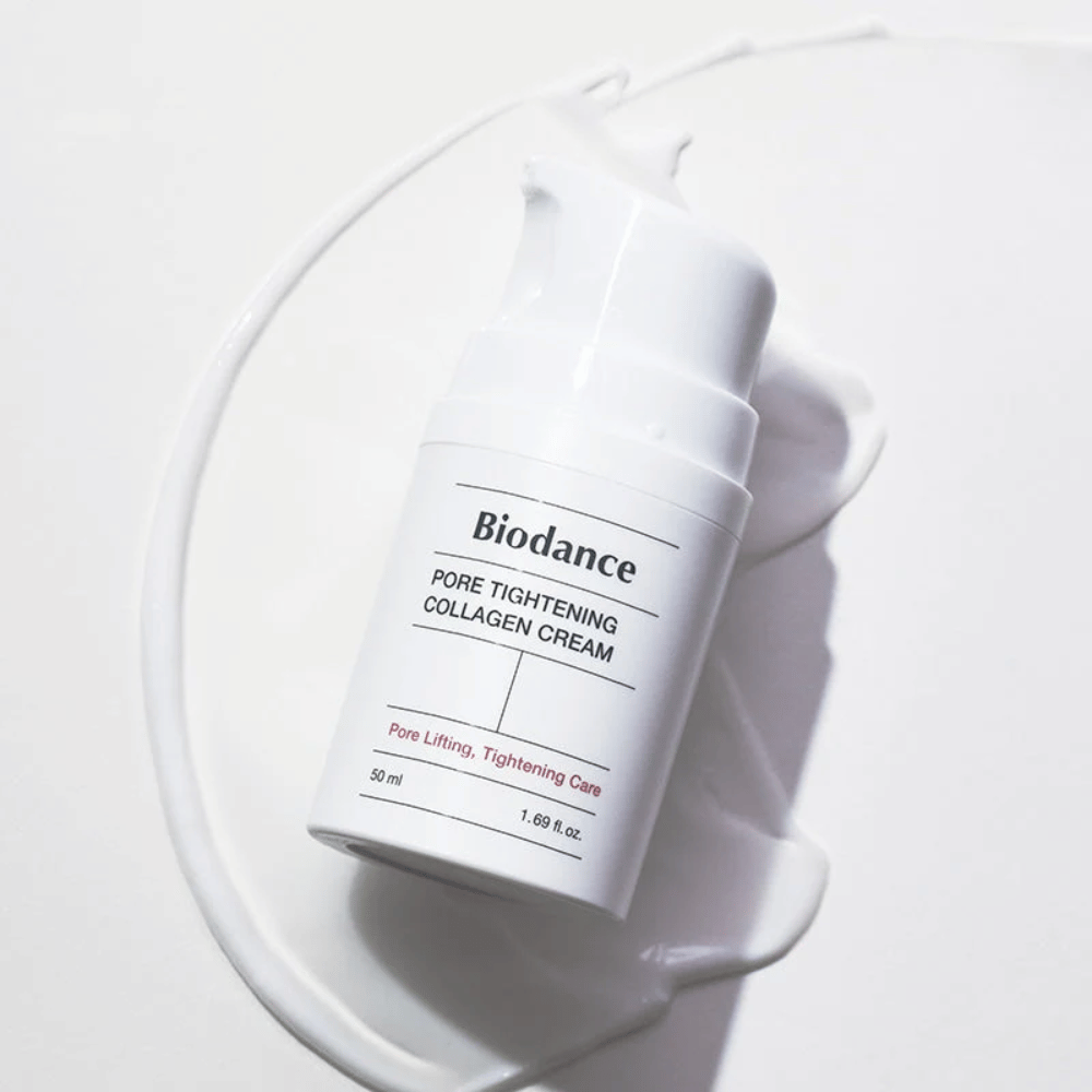 Biodance Pore Tightening Collagen Cream i hvit pumpeflaske, liggende på en swirl av hvit krem.