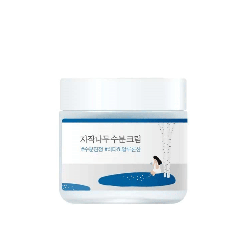 Round Lab Birch Juice Moisturizing Cream i gjennomsiktig boks med hvitt lokk og blå etikett med illustrasjon av bjørk og jente, frilagt mot hvit bakgrunn.