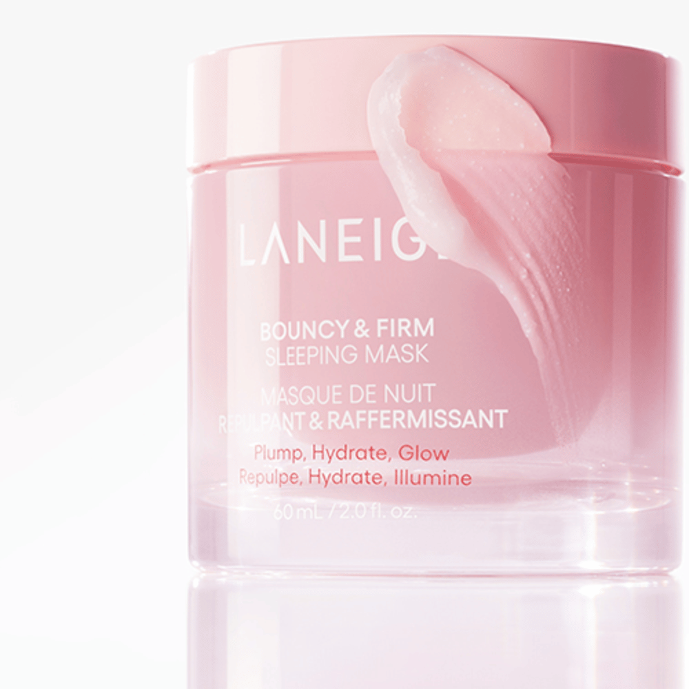 Nærbilde av Laneige Bouncy & Firm Sleeping Mask i en rosa krukke, med en del av masken som påføres på kanten av lokket. Produktet er ment å gi plump, fuktighet og glød. Krukken rommer 60 ml og har teksten "Plump, Hydrate, Glow."