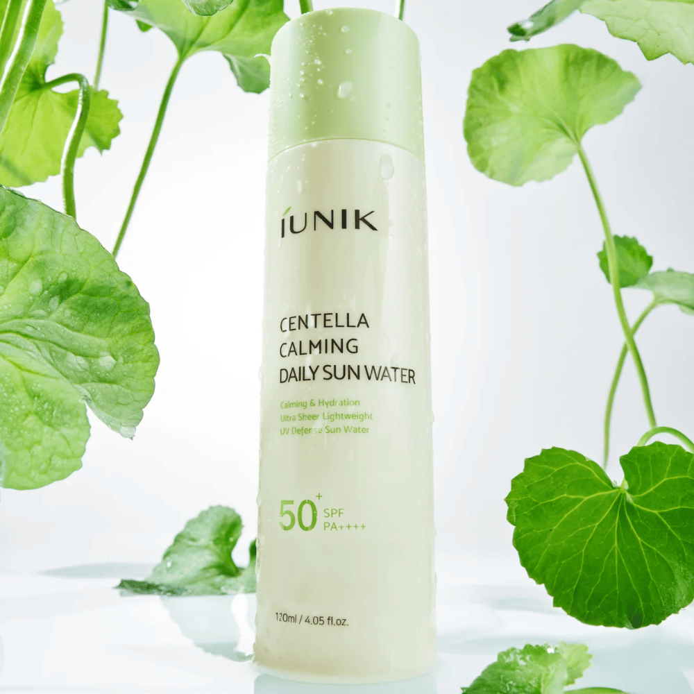 2. iUNIK Centella Calming Daily Sun Water SPF50+ PA++++ – fuktighetsgivende solbeskyttelse med centella asiatica omgitt av grønne blader og vanndråper