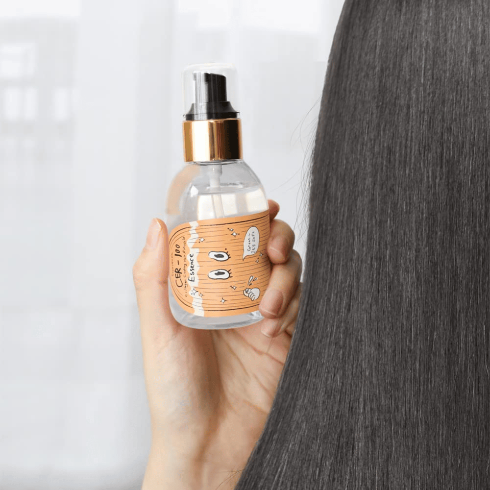 Person holder CER-100 Hair Essence ved siden av langt, glansfullt hår for å vise mykhet og pleie.