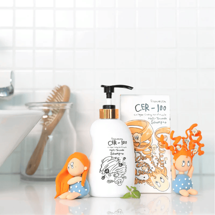 Elizavecca CER-100 Shampoo og esken vises i et baderomsmiljø ved siden av hårbørste og dekorative figurer. Bildet formidler en hverdagslig hårpleierutine og produktets bruk i hjemmemiljø.