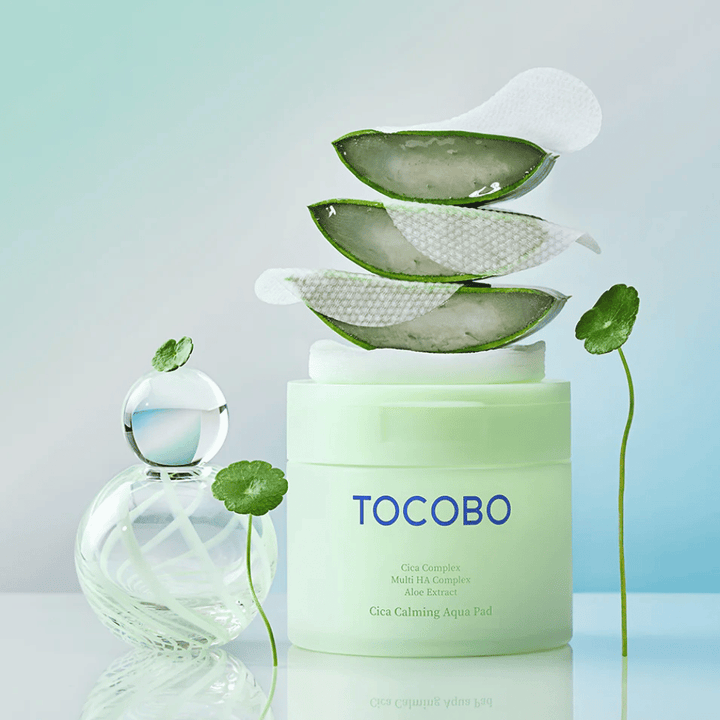 TOCOBO Cica Calming Aqua Pad vises sammen med toner pads, aloe vera og centella asiatica. Bildet fremhever produktets fuktgivende og beroligende ingredienser.