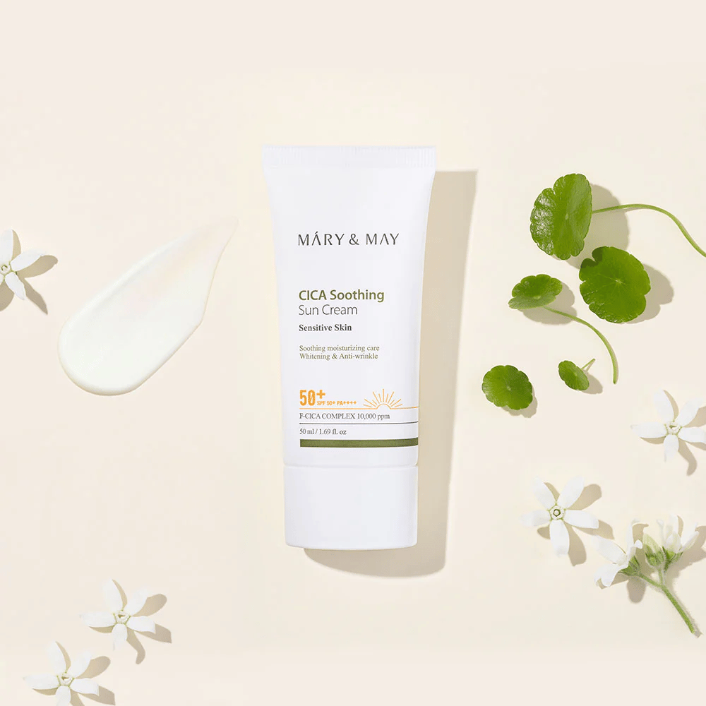 Mary&May CICA Soothing Sun Cream SPF50+ PA++++ presentert sammen med en kremtekstur, centella-blader og hvite blomster. Bildet fremhever produktets beroligende egenskaper og fokus på sensitiv hud.