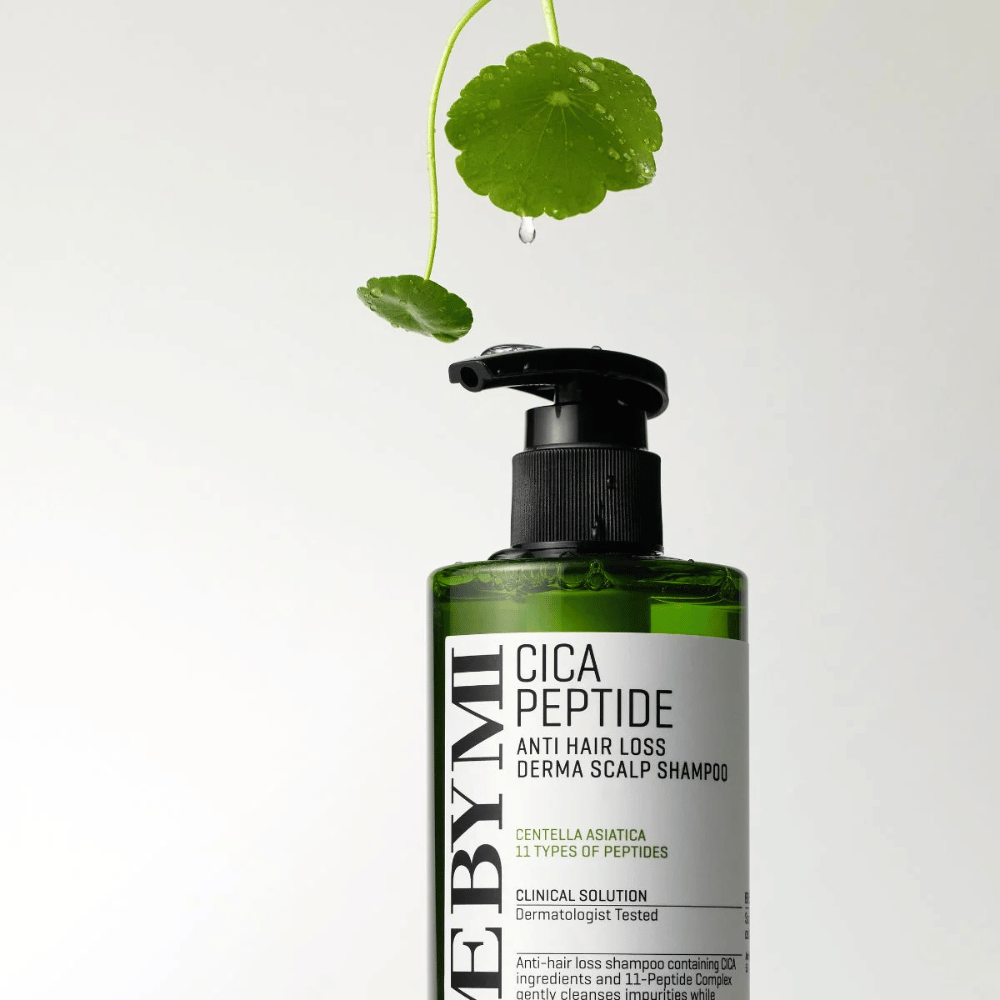 Flaske med SOME BY MI Cica Peptide Anti Hair Loss Derma Scalp Shampoo i grønt med svart pumpe og hvit etikett, omgitt av centellablader og en vanndråpe.