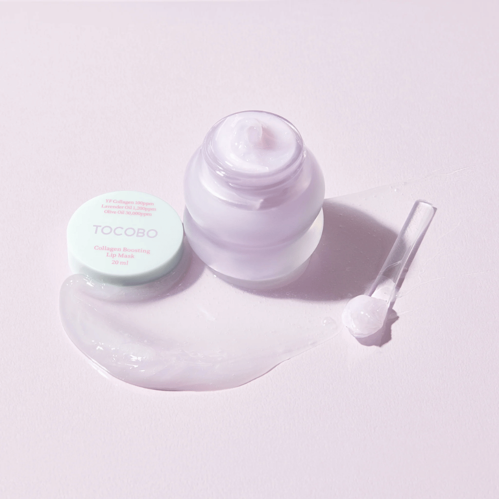 Åpen krukke TOCOBO Collagen Boosting Lip Mask med spatel og utsmurt lilla krem på lys lilla bakgrunn.
