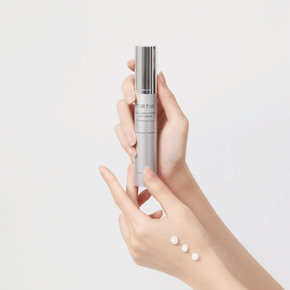 Hender som holder en tube med TIRTIR Collagen Lifting Eye Cream, med produkt presset ut på håndbaken.