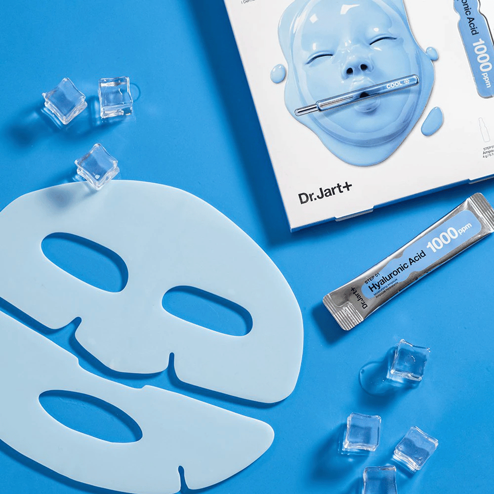 Dr.Jart+ Cryo Rubber Moisturizing Mask med tvådelad blå gummimask, isbitar, hyaluronsyraampull och förpackning mot blå bakgrund.
