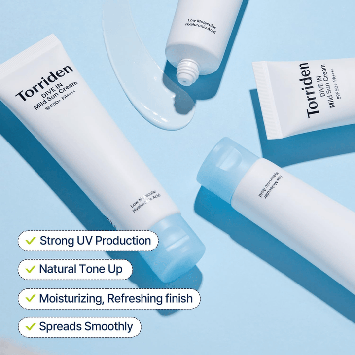 Flere tuber av Torriden DIVE-IN Mild Sun Cream ligger spredt utover på en blå bakgrunn med litt produkt smurt utover. Teksten fremhever fordeler som UV-beskyttelse, fuktighet og jevn påføring.