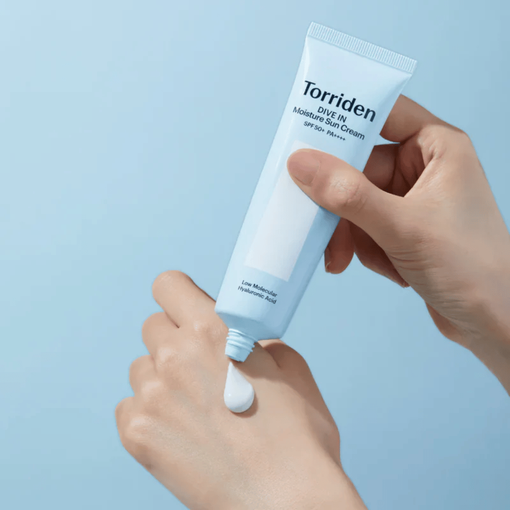 Torriden DIVE-IN Moisture Sun Cream SPF50+ PA++++ påføres på hånden for å vise den fuktgivende solkremens lette og kremete konsistens.