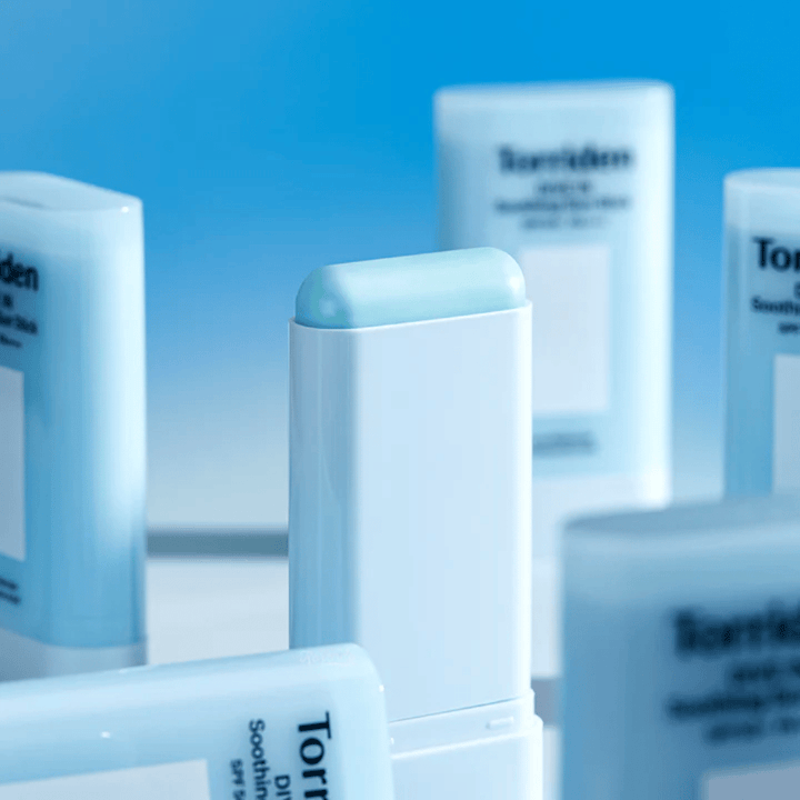 Nærbilde av Torriden DIVE IN Soothing Sun Stick som viser den myke solbeskyttelsesformelen i stickformat med flere produkter i bakgrunnen.