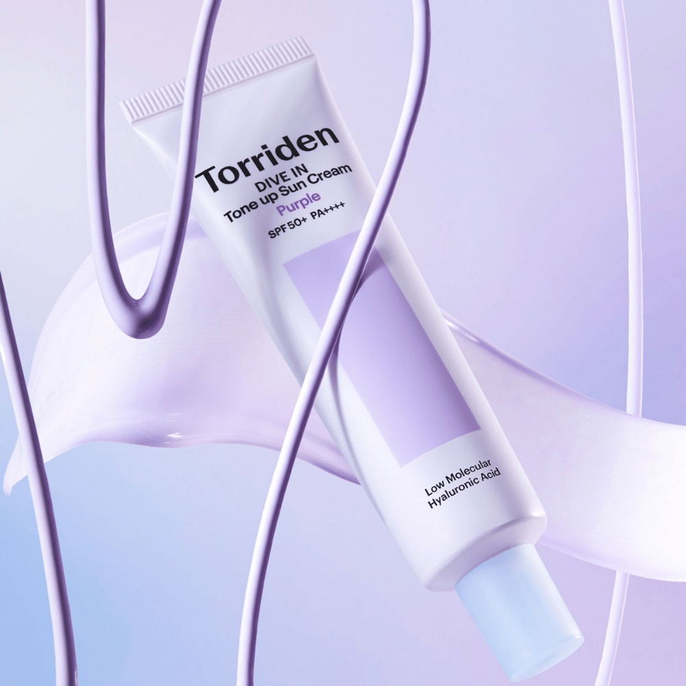 Torriden DIVE IN Tone Up Sun Cream Purple SPF50+ PA++++ presentert i et kreativt produktmiljø med lilla detaljer som fremhever den fuktighetsgivende formelen.