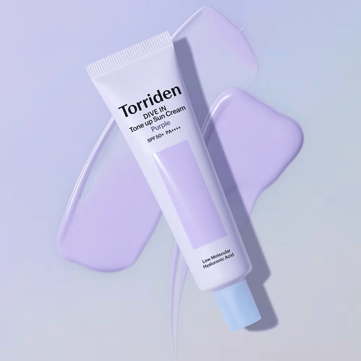 Torriden DIVE IN Tone Up Sun Cream Purple plassert på utsmurt lilla krem som fremhever den toneutjevnende og glødgivende effekten.