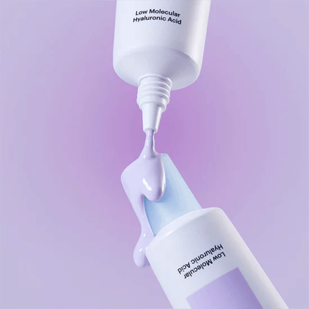 Nærbilde av Torriden DIVE IN Tone Up Sun Cream Purple der den lilla kremen påføres fra tuben for å illustrere produktets konsistens.