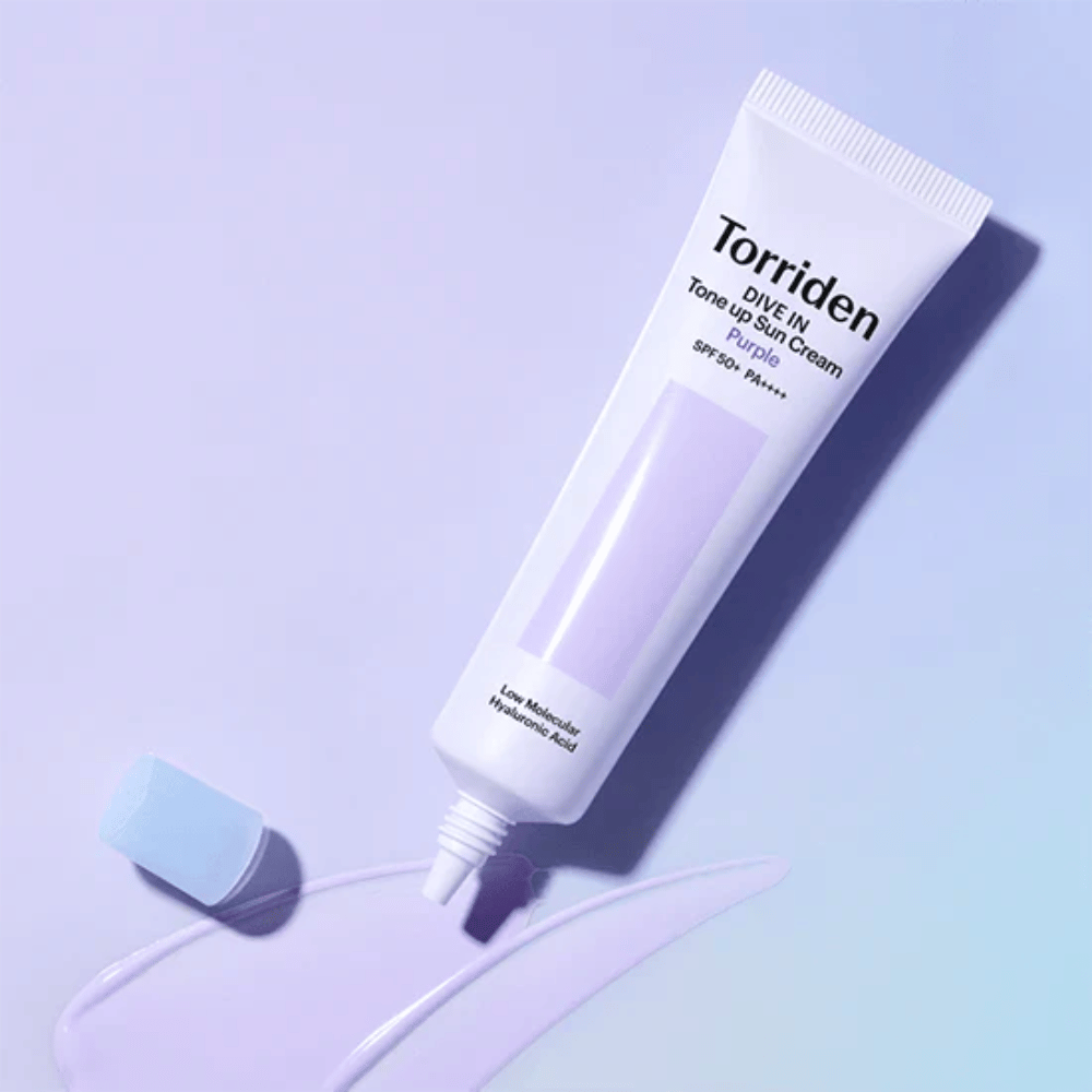 Åpen tube av Torriden DIVE IN Tone Up Sun Cream Purple med lilla-tonet solkremtekstur som viser produktets fargekorrigerende formel.