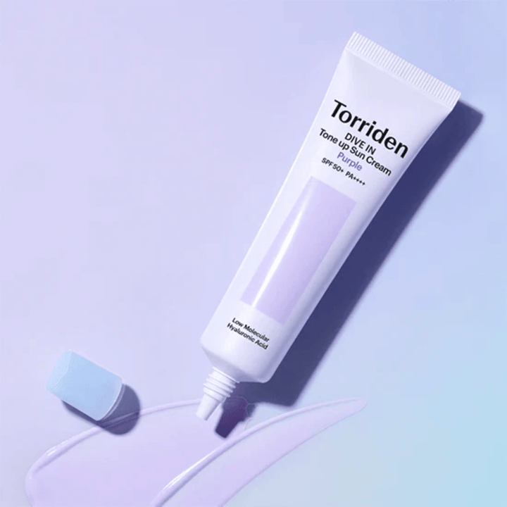 Åpen tube av Torriden DIVE IN Tone Up Sun Cream Purple med lilla-tonet solkremtekstur som viser produktets fargekorrigerende formel.