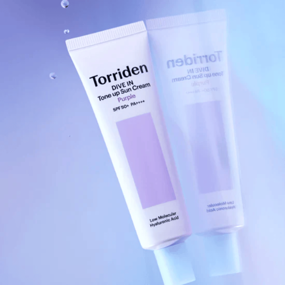 Torriden DIVE IN Tone Up Sun Cream Purple SPF50+ PA++++ fotografert mot myk lilla bakgrunn som fremhever produktets lysreflekterende design.