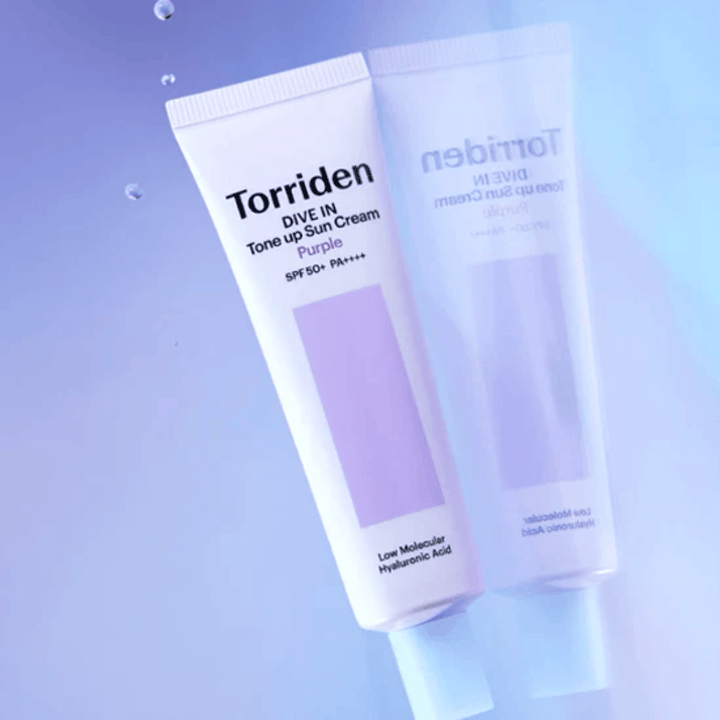 Torriden DIVE IN Tone Up Sun Cream Purple SPF50+ PA++++ fotografert mot myk lilla bakgrunn som fremhever produktets lysreflekterende design.