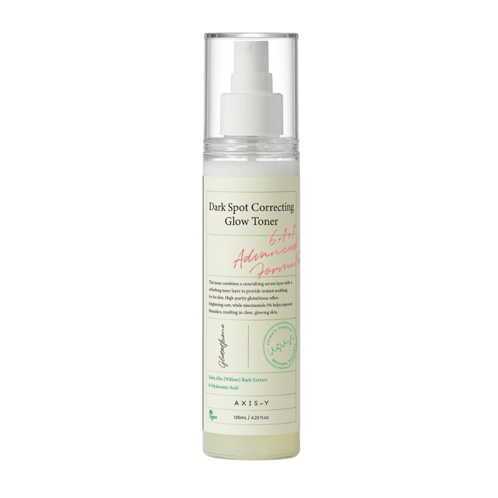 Et bilde av en flaske av produktet "AXIS-Y Dark Spot Correcting Glow Toner". Flasken er gjennomsiktig med en hvit etikett og tekst i svart og grønt. Produktet er en toner i sprayform, og flasken inneholder 125 ml (4,23 fl. oz). Etiketten nevner nøkkelingredienser som Willow Bark Extract og Hyaluronic Acid.