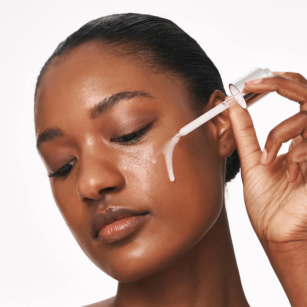 Person påfører Deep Collagen Power Boosting Cream in Serum på kinnet med pipette. Serumet gir fastere, fuktet hud med glød.
