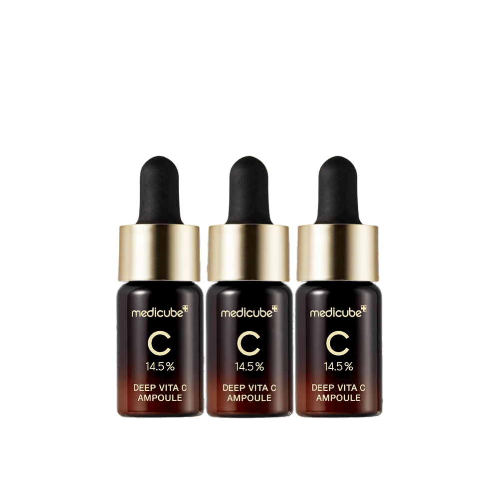 Tre flasker av Medicube Deep Vita C Ampoule, med 14,5 % C-vitamin, arrangert på rad. Flaskene har en elegant design med mørkebrun bunn og gullfarget kork. Perfekt for lysere hudtone og jevnere hudtekstur.