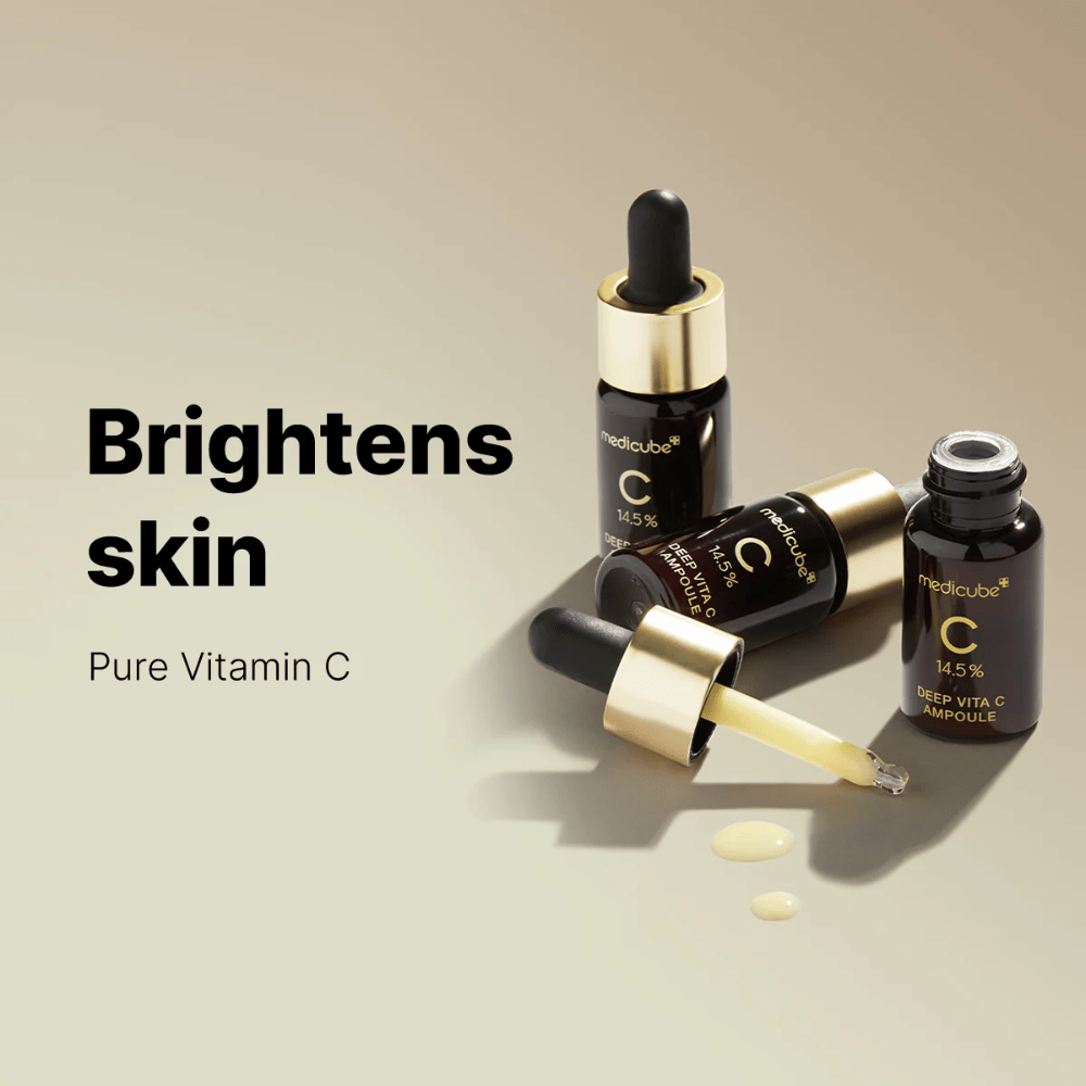 Medicube Deep Vita C Ampoule med 14,5 % C-vitamin, vises i elegante flasker med gullfargede pipetter. Produktet er designet for å lysne hudtonen og gi en strålende hud. Teksten "Brightens skin" og "Pure Vitamin C" forsterker budskapet.