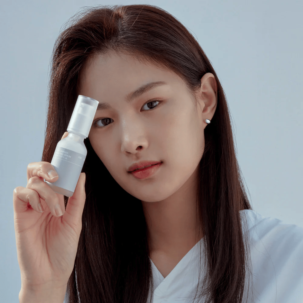 Modell holder Celimax Dual Barrier Boosting Serum, koreansk hudpleie som styrker hudbarrieren og beroliger sensitiv hud.