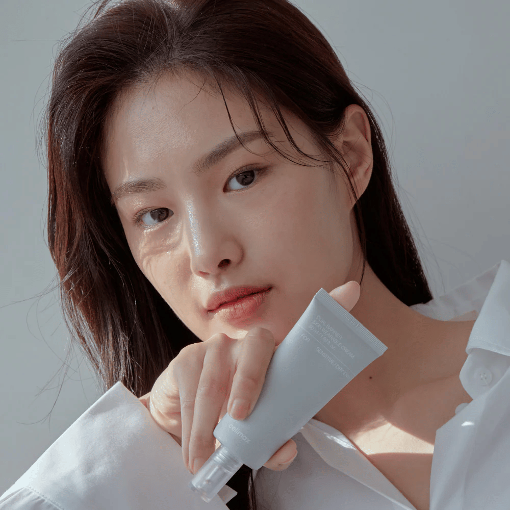 Modell som holder Celimax Dual Barrier Skin Wearable Cream, beroligende og barriereforsterkende ansiktskrem for sensitiv hud og tørr hud.