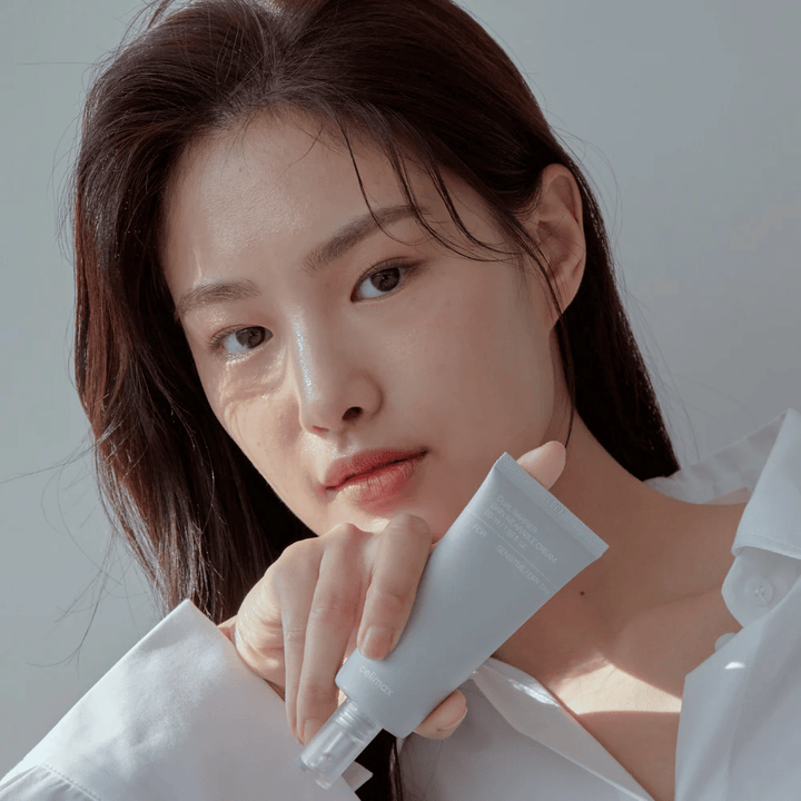 Modell som holder Celimax Dual Barrier Skin Wearable Cream, beroligende og barriereforsterkende ansiktskrem for sensitiv hud og tørr hud.